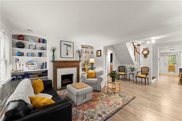 233 Spence Ave SE, Atlanta, GA 30317 - living room with stairway, light wood finished floors, ornamental molding, and a brick fireplace