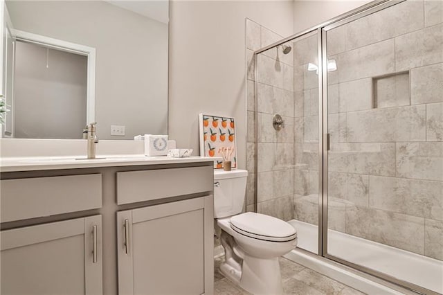 bathroom featuring toilet, vanity, and walk in shower