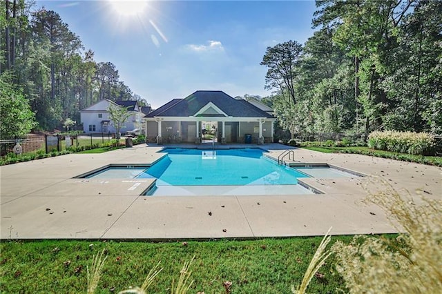 view of swimming pool with a diving board and a patio