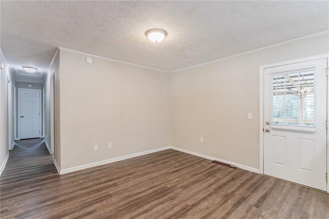 spare room with a textured ceiling, dark wood-type flooring, and ornamental molding