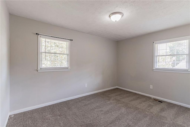 empty room with a textured ceiling and carpet