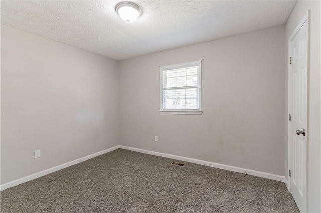 empty room with a textured ceiling and carpet