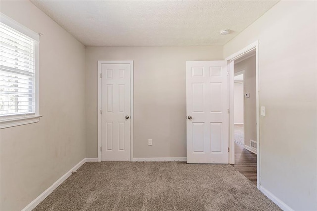 unfurnished bedroom featuring carpet and multiple windows