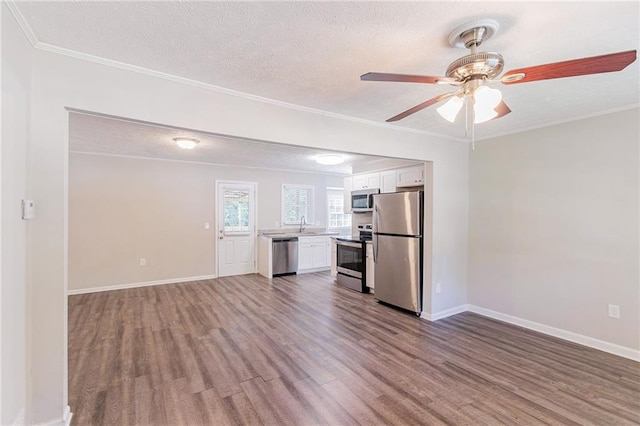 interior space with ceiling fan, ornamental molding, and wood-type flooring