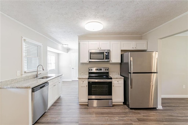 kitchen with appliances with stainless steel finishes, hardwood / wood-style flooring, sink, and white cabinets