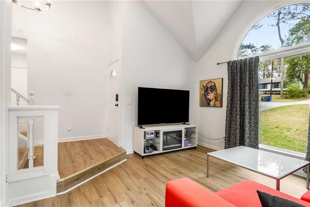 7275 Oswego Trl, Riverdale, GA 30296 - living room with wood finished floors, high vaulted ceiling, and baseboards