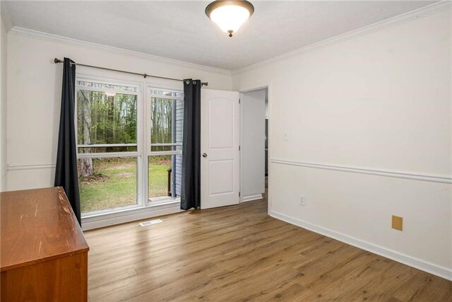 7275 Oswego Trl, Riverdale, GA 30296 - spare room featuring visible vents, baseboards, crown molding, and wood finished floors