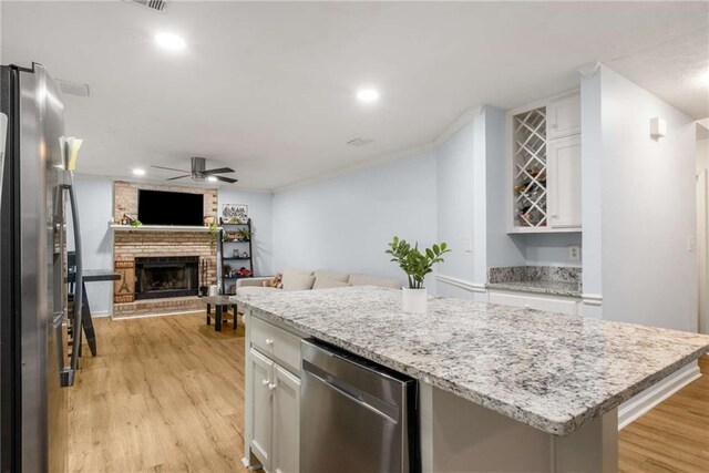 7275 Oswego Trl, Riverdale, GA 30296 - kitchen with light wood-type flooring, open floor plan, white cabinets, ceiling fan, and appliances with stainless steel finishes