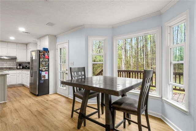 7275 Oswego Trl, Riverdale, GA 30296 - dining area featuring light wood finished floors, baseboards, ornamental molding, and visible vents