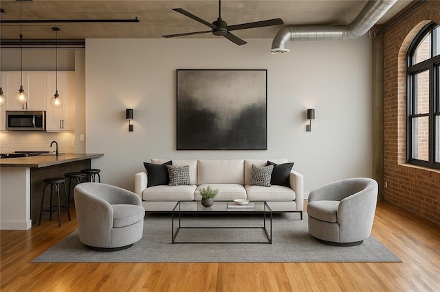 3235 Roswell Rd NE Unit 521, Atlanta, GA 30305 - living area with brick wall, light wood-style flooring, and ceiling fan