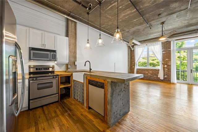 3235 Roswell Rd NE Unit 521, Atlanta, GA 30305 - kitchen with stainless steel appliances, wood counters, a peninsula, dark wood finished floors, and a sink