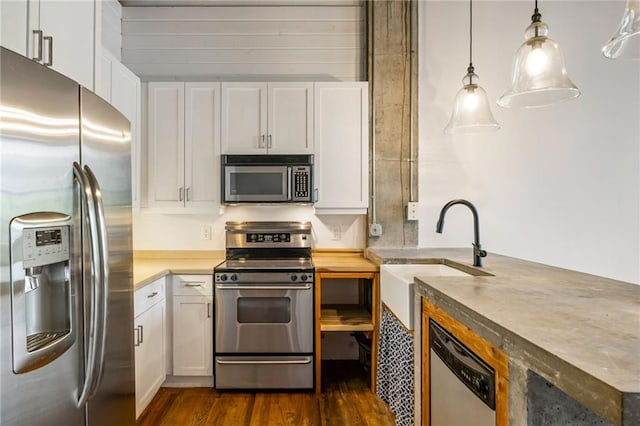3235 Roswell Rd NE Unit 521, Atlanta, GA 30305 - kitchen with stainless steel appliances, a sink, dark wood-style flooring, white cabinetry, and decorative light fixtures