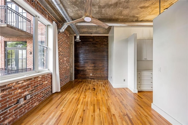 3235 Roswell Rd NE Unit 521, Atlanta, GA 30305 - spare room with brick wall, light wood-style flooring, and baseboards