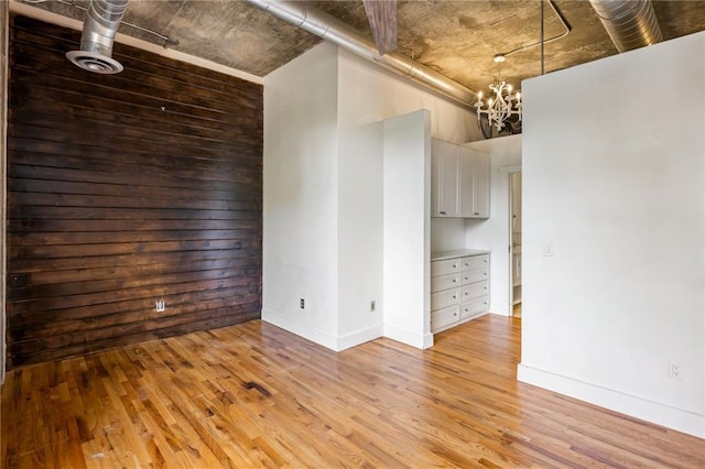 3235 Roswell Rd NE Unit 521, Atlanta, GA 30305 - unfurnished room with light wood-type flooring, a chandelier, and baseboards