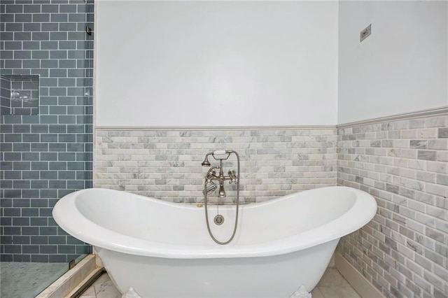 3235 Roswell Rd NE Unit 521, Atlanta, GA 30305 - bathroom with tile walls, a soaking tub, and a wainscoted wall