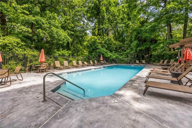 3235 Roswell Rd NE Unit 521, Atlanta, GA 30305 - community pool featuring a patio area, fence, and view of wooded area