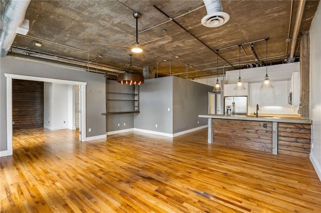 3235 Roswell Rd NE Unit 521, Atlanta, GA 30305 - unfurnished living room featuring light wood-style flooring, baseboards, and a sink