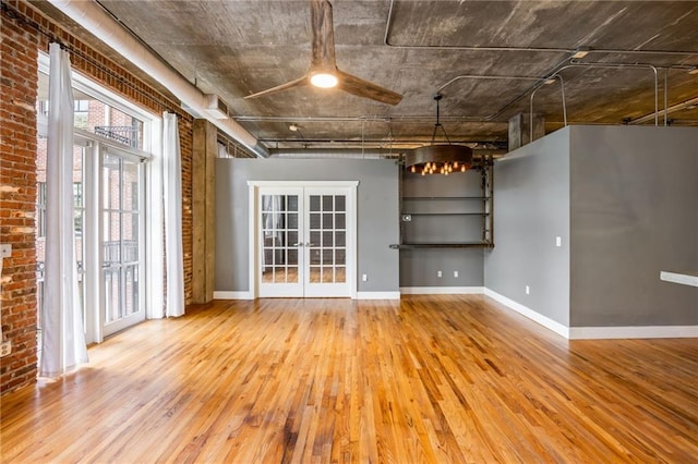 3235 Roswell Rd NE Unit 521, Atlanta, GA 30305 - spare room featuring wood finished floors, french doors, a chandelier, baseboards, and brick wall