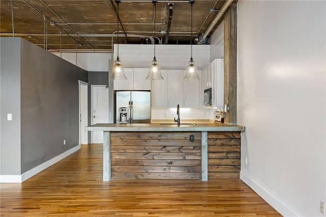 3235 Roswell Rd NE Unit 521, Atlanta, GA 30305 - kitchen with stainless steel appliances, white cabinets, wood finished floors, a sink, and baseboards