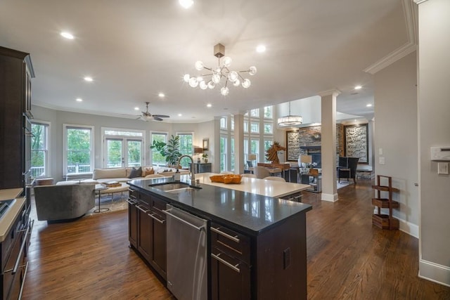 kitchen featuring stainless steel dishwasher, a fireplace, open floor plan, and a sink