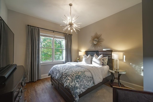 bedroom featuring a notable chandelier, wood finished floors, and baseboards