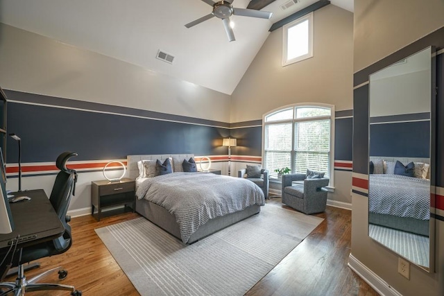 bedroom featuring visible vents, multiple windows, high vaulted ceiling, and wood finished floors