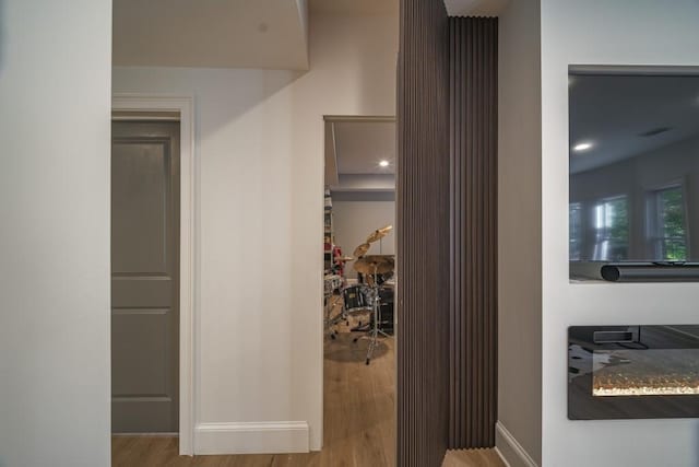 hall featuring wood finished floors and baseboards