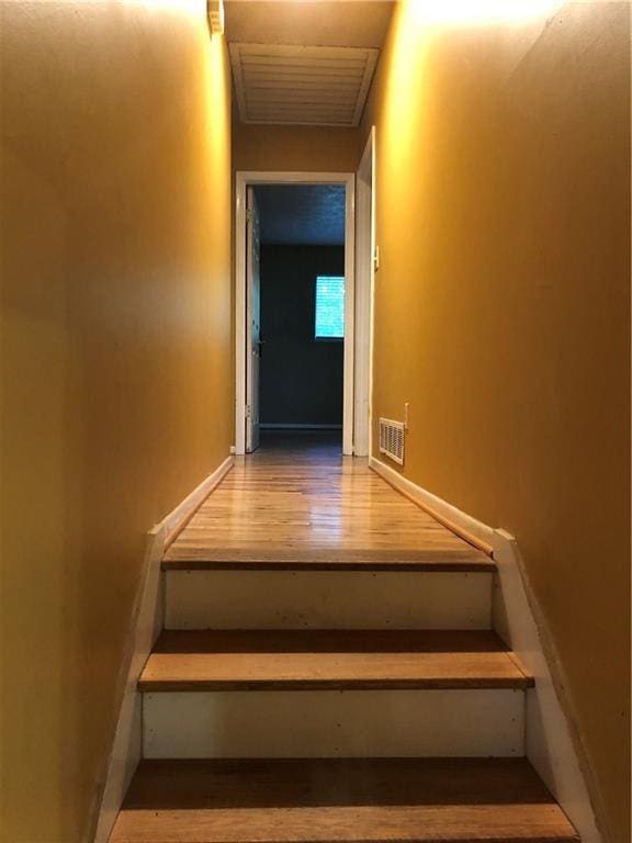 staircase with visible vents and wood finished floors