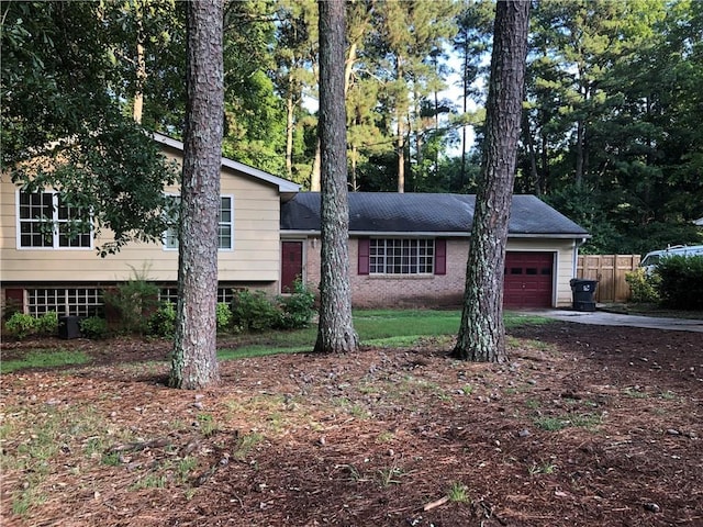 view of front of home featuring an attached garage, fence, and driveway