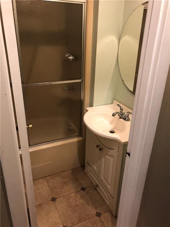 bathroom with tile patterned flooring, vanity, and shower / bath combination with glass door