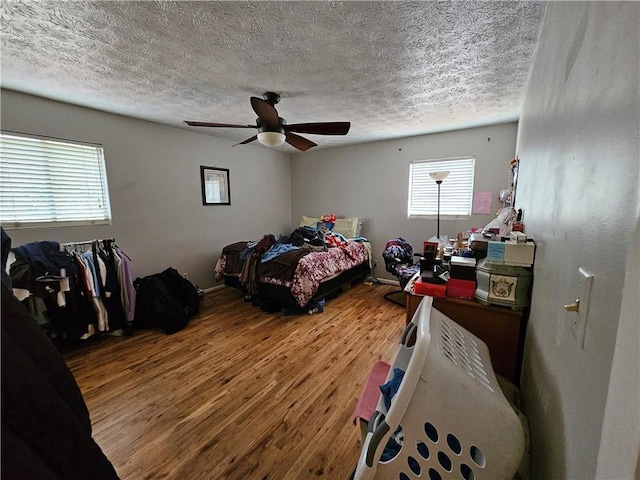 bedroom featuring ceiling fan, a textured ceiling, and wood finished floors