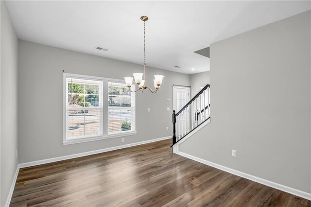 interior space with dark wood-type flooring and an inviting chandelier