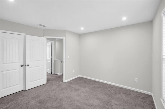 unfurnished bedroom with a closet and light colored carpet