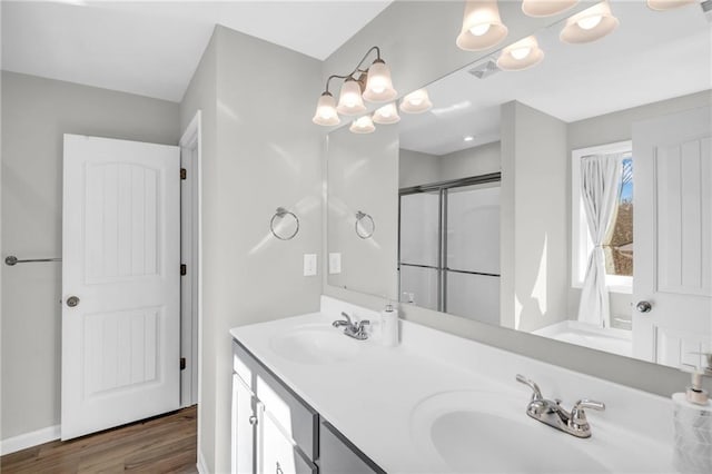 bathroom featuring wood-type flooring, vanity, and a shower with shower door