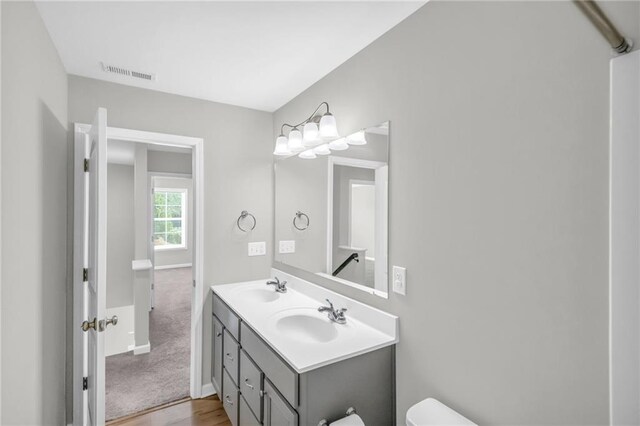 bathroom with vanity, toilet, and wood-type flooring