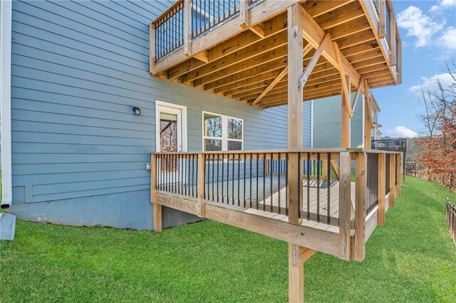 wooden deck featuring a lawn