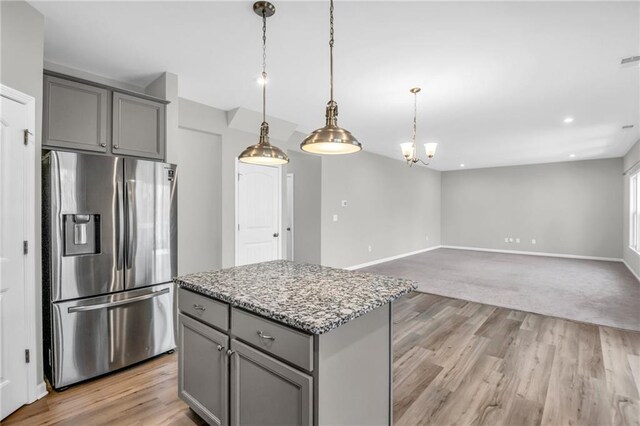 kitchen with pendant lighting, a chandelier, stainless steel fridge with ice dispenser, a center island, and gray cabinets