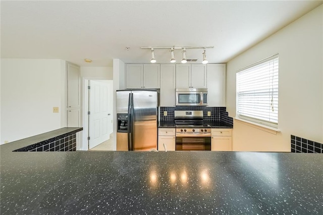 kitchen featuring white cabinetry, stainless steel appliances, and backsplash