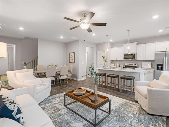 living room with dark hardwood / wood-style floors and ceiling fan