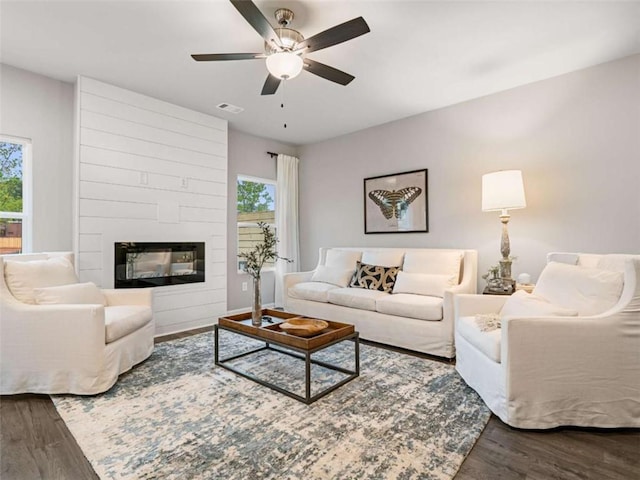 living room with a fireplace, hardwood / wood-style flooring, and plenty of natural light