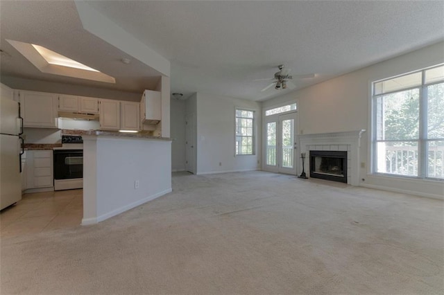 1015 Mcgill Park Ave NE, Atlanta, GA 30312 - unfurnished living room featuring light carpet, ceiling fan, baseboards, and a tile fireplace