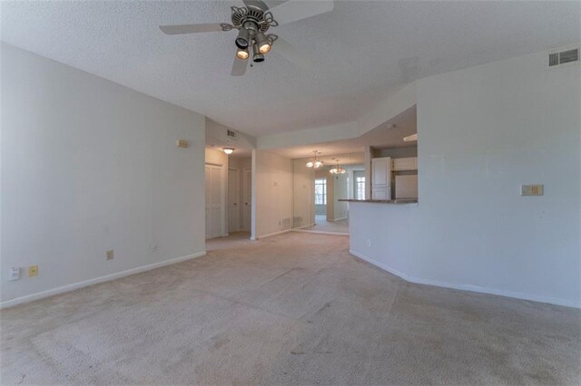 1015 Mcgill Park Ave NE, Atlanta, GA 30312 - unfurnished living room featuring light colored carpet, baseboards, ceiling fan, and a chandelier