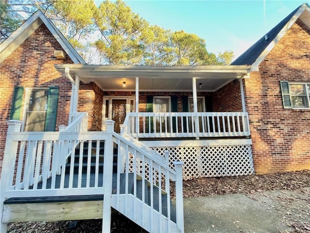 exterior space with covered porch and brick siding