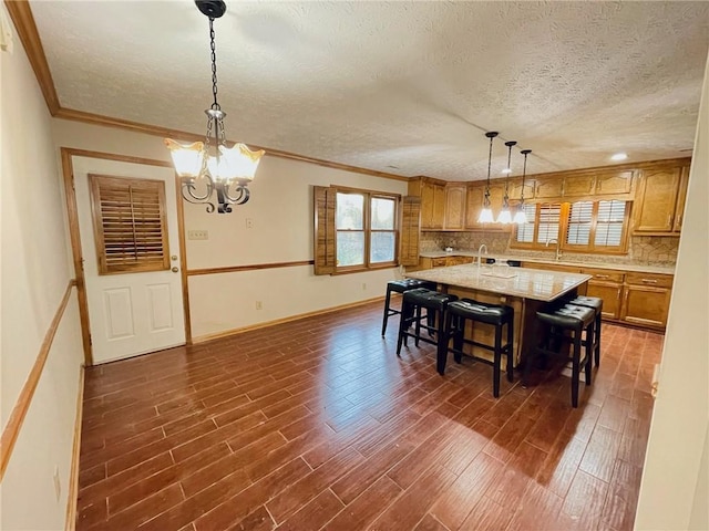 dining room with a chandelier, a textured ceiling, baseboards, ornamental molding, and dark wood finished floors