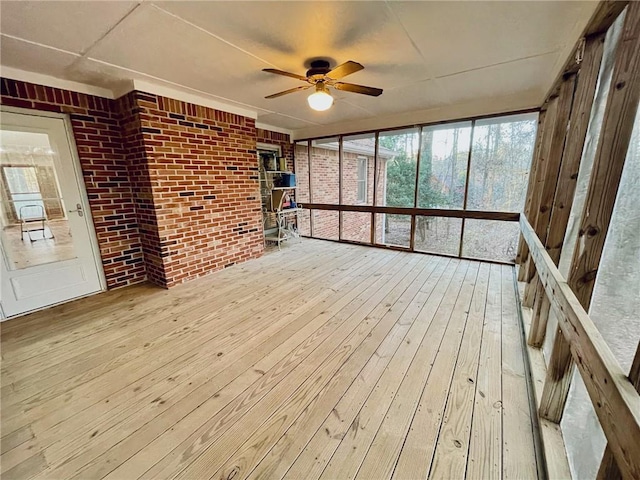 unfurnished sunroom with a ceiling fan