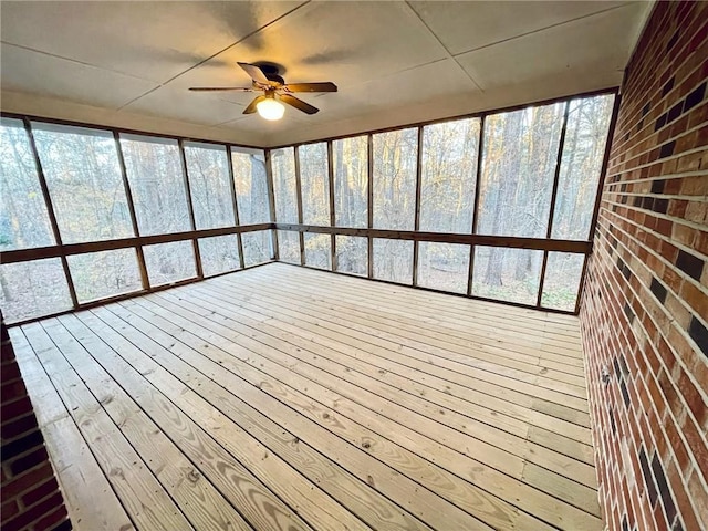 unfurnished sunroom featuring a ceiling fan