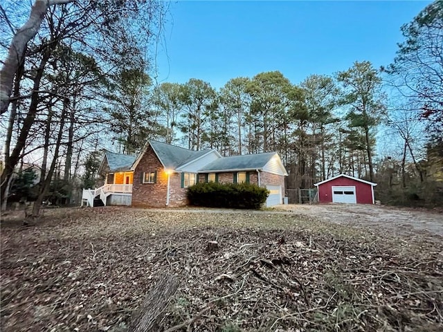 view of front of home featuring a garage, an outbuilding, and driveway