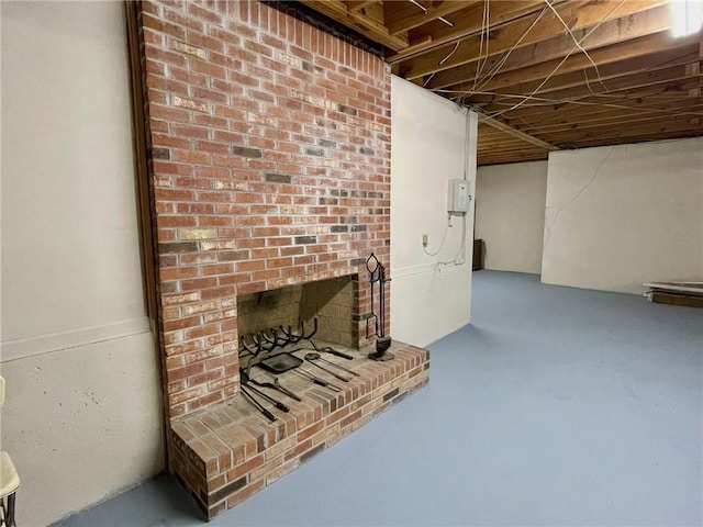 unfinished basement featuring a brick fireplace