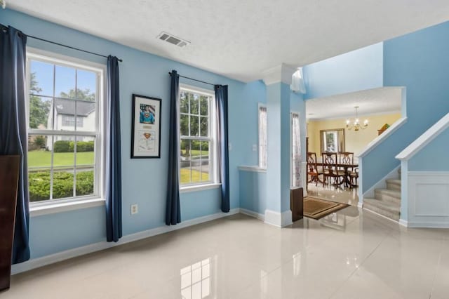 570 White Stag Ct, Suwanee, GA 30024 - foyer entrance featuring a chandelier, tile patterned flooring, a textured ceiling, baseboards, and stairs