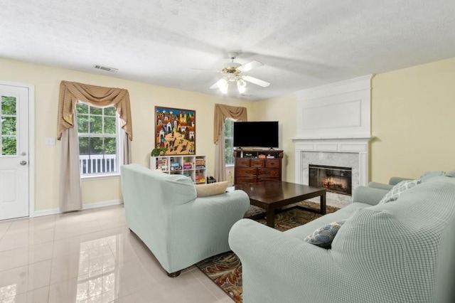 570 White Stag Ct, Suwanee, GA 30024 - living room featuring a ceiling fan, a fireplace, light tile patterned floors, a textured ceiling, and baseboards